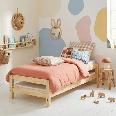 A child's bedroom with a bed, shelf, and decorative elements.