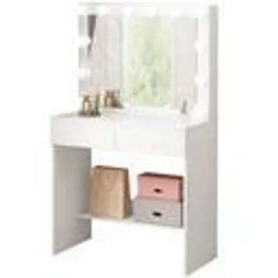 A white vanity table with a mirror and lights, featuring storage drawers and shelves with decorative items.