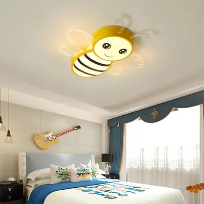 A child's bedroom with a bee-shaped ceiling light.