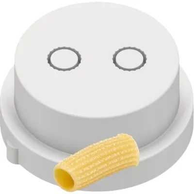 A close-up of a white pasta maker die with a single rigatoni pasta noodle in front of it.