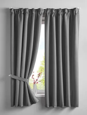 Two gray curtains are shown hanging in front of a window. One curtain is tied back with a fabric tie.