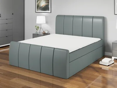 A modern bedroom with a gray upholstered boxspring bed.