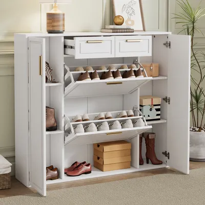A white shoe cabinet with gold handles and drawers, filled with shoes and boxes, set in a room.