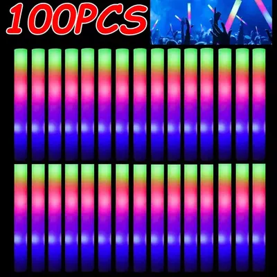 A group of people at a concert or event holding up glowing LED foam sticks.