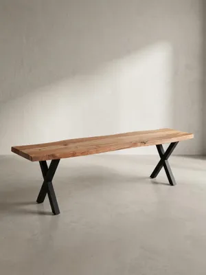Dreiviertelansicht der 160 cm langen Holzbank, die die Tiefe der massiven Akazienholzplatte und die robuste Konstruktion der X-förmigen Beine zeigt._#sku_SAFWL7.299#
