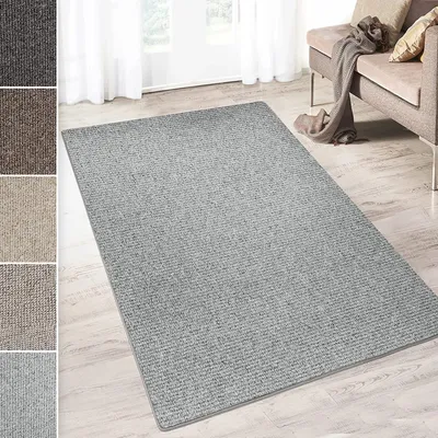 A light gray carpet is laid out on a light wooden floor in a room with white curtains and a sofa in the background.