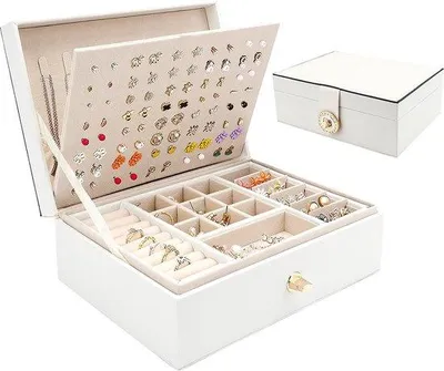 Imagen del producto de Caja para joyas Unyqoos® de cuero sintético PU, color blanco, con dimensiones de 23 x 17 x 8,5 cm, forrada en terciopelo y con cierre de metal. Incluye 8 ganchos para collares, 80 orificios para pendientes, 9 compartimentos para anillos y 6 compartimentos para pulseras