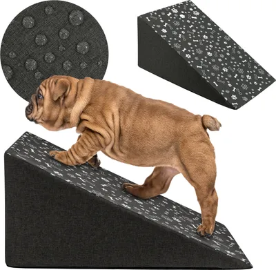 A puppy is climbing a pet ramp with a paw and bone pattern. A close-up of the ramp's fabric texture is shown in a circle.