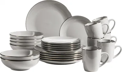 A set of white ceramic dishes with a metallic rim, including plates, bowls, and mugs, arranged on a white background.