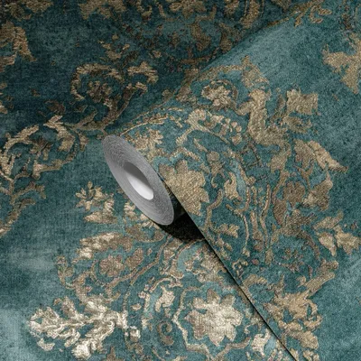 A close-up view of a roll of teal-colored wallpaper with a gold baroque pattern.