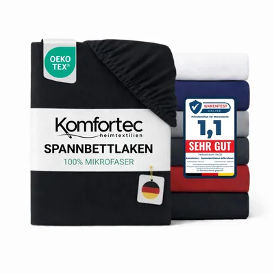 A stack of folded fitted sheets in various colors, with one black sheet prominently displayed in the foreground with product labeling.