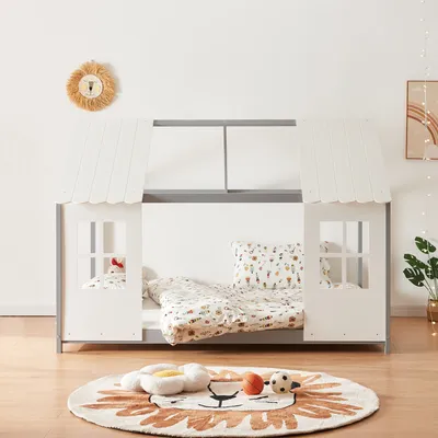 A children's bed designed to look like a house, with bedding and pillows inside.