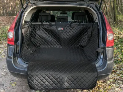 The rear of a car with the trunk open, showing a black quilted trunk liner installed.