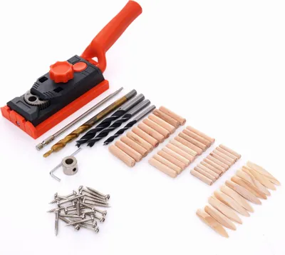 A set of woodworking tools, including a jig, drill bits, dowels, and screws, laid out on a white background.