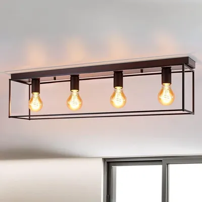 A black, rectangular ceiling light fixture with four exposed Edison-style bulbs is mounted on a white ceiling.