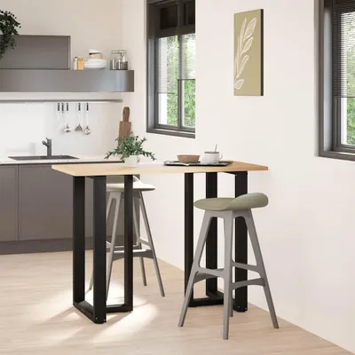A modern kitchen with a bar table and stools.