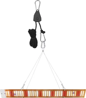 A grow light panel suspended by a pulley system.