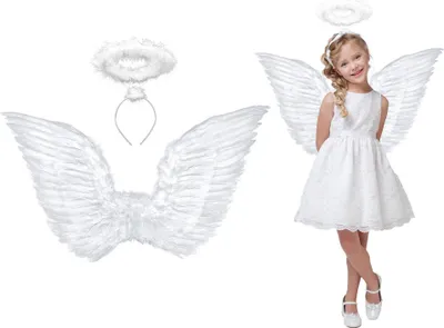 A young girl dressed as an angel, wearing a white dress, wings, and halo, posing for a photo. Beside her are the angel wings and halo set.