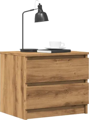 A wooden nightstand with two drawers, a black desk lamp, a book, and a cup of coffee on top.