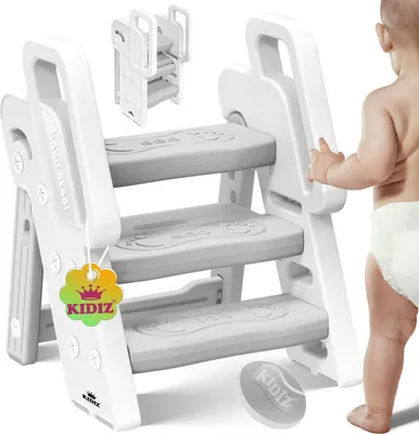 A baby reaching for a white step stool.