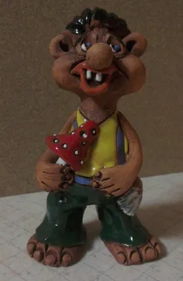 Keramikfigur, die einen karikaturhaften Mann darstellt, der einen roten Pilz mit weißen Punkten hält