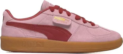 A side view of a pink Puma sneaker with red accents and a gum sole.