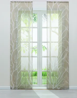 Two sheer curtains with a white branch pattern hang in front of a French door, with greenery visible outside.