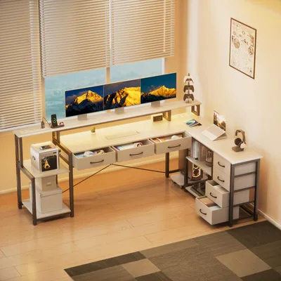 An L-shaped desk with multiple monitors, drawers, and shelves, set up in a home office environment.