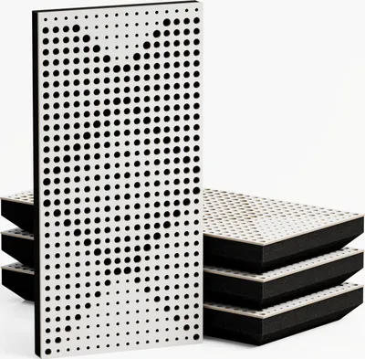 A stack of acoustic panels with a white perforated surface and black foam backing, with one panel standing upright in the foreground.