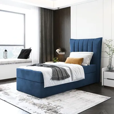 A bedroom scene with a blue upholstered bed, white bedding, and decorative pillows.