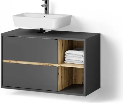 A modern bathroom vanity with a sink and faucet above it. The vanity is dark gray with wood-grain accents and open shelving holding folded towels.