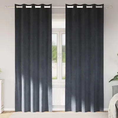 Two dark gray velvet curtains hanging in front of a window.