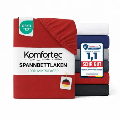 A stack of folded bed sheets in various colors, with one red sheet prominently displayed in the foreground, featuring product branding and certifications.