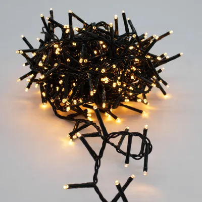 A tangled bundle of warm white LED string lights on a light gray background.