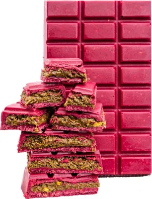 A stack of broken chocolate bar pieces in front of a full chocolate bar.