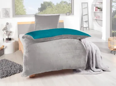 A bedroom scene with a bed made up with bedding.