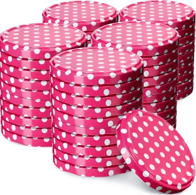 Stacks of pink jar lids with white polka dots.