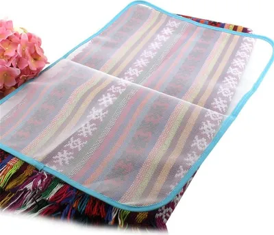 A close-up, slightly angled view of a ironing cloth with a woven pattern and fringe, placed on a white background.