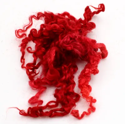 A pile of red wool fibers with a curly texture.