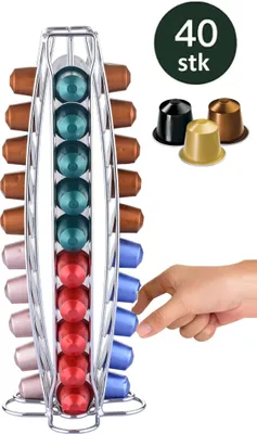 A hand is reaching for coffee capsules in a rotating dispenser. There are also loose coffee capsules shown in the background.