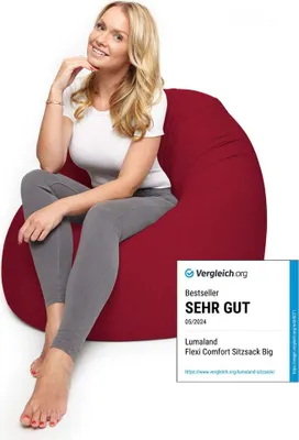 A woman is sitting on a red beanbag chair.