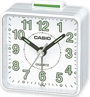A white Casio analog alarm clock with a green snooze button on top.