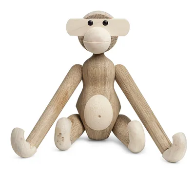 A wooden monkey toy sitting on a white background.