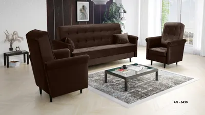 A living room setting with a brown couch and two matching armchairs, a coffee table, and a rug.