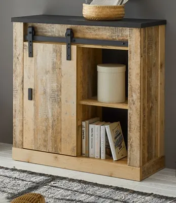 A wooden cabinet with a sliding door and shelves, displaying books and a decorative container.