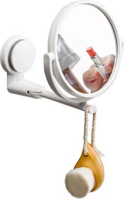A white makeup mirror with a suction cup mount is shown, with a facial cleansing brush hanging from it.