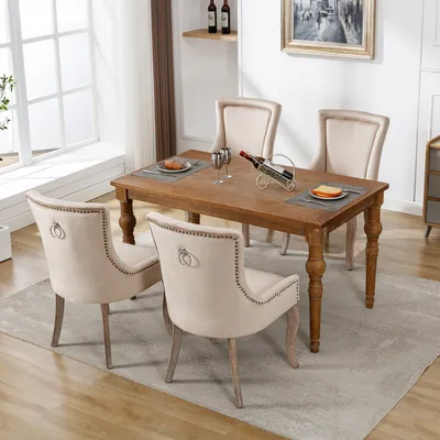 A dining room set with a wooden table and four beige upholstered chairs.