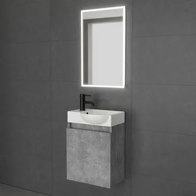 A modern bathroom vanity set with a sink, faucet, and illuminated mirror mounted on a gray tiled wall.