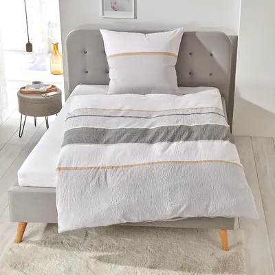 A neatly made bed with bedding and a pillow.