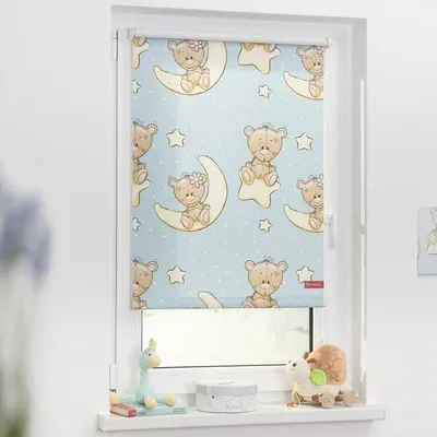 A roller blind with a teddy bear pattern is shown hanging in a window.